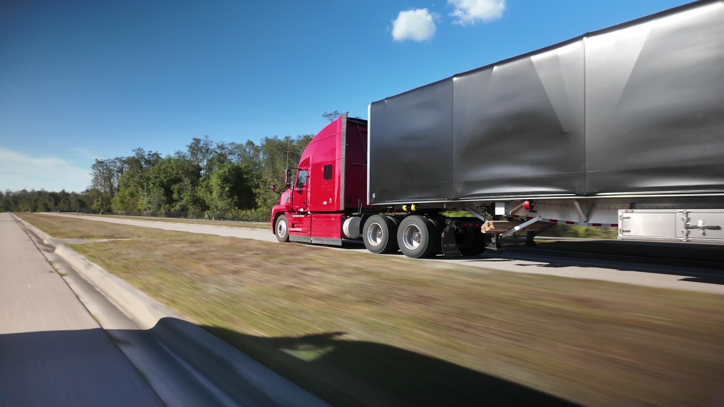 The League truck and conestoga on the highway.
