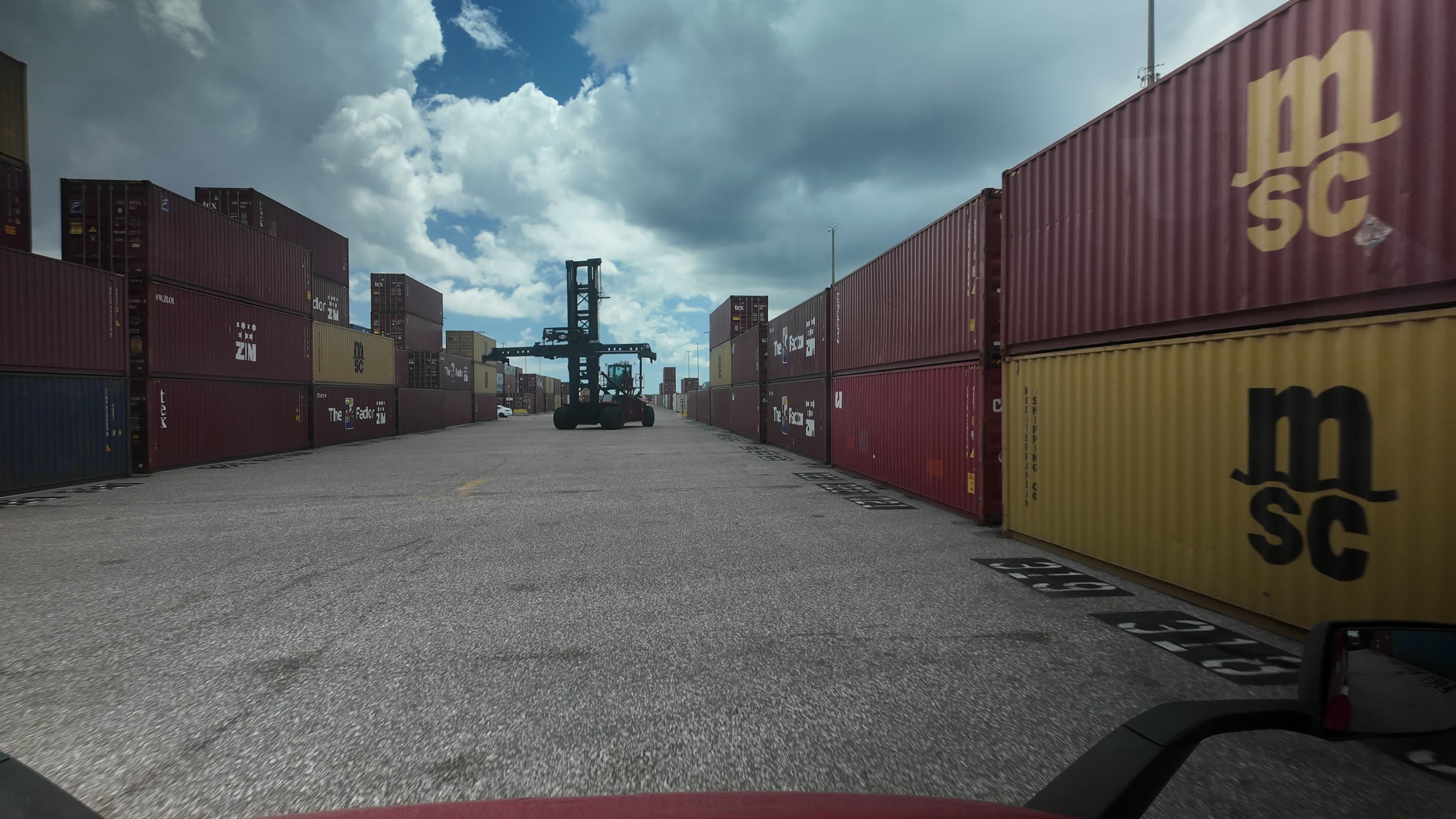 Container stacks at the Port of Tampa, seen from the cab of a League truck.